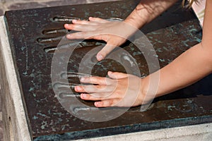 Children hands in metal handprints