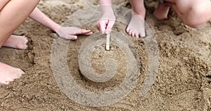 Children hands play and build sand castles on beach in summer
