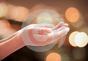 Children hands praying over abstract blurred spiritual light