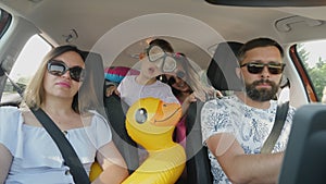 Children are happy to travel on vacation at sea while sitting in the back seats in the car