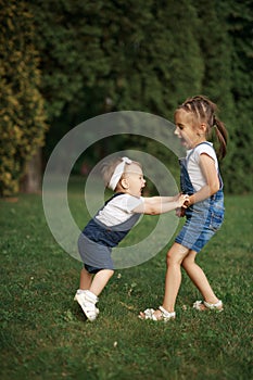 Children have fun holding hands, running and jumping in the park on a summer day