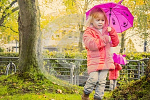 children have fun under an umbrella, in the autumn afternoon