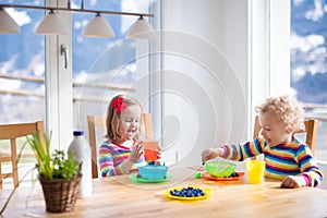 Children having breakfast in sunny kitchen