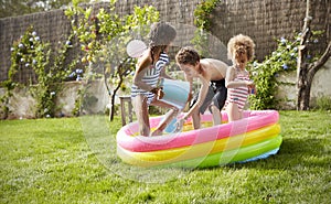 Children Having Fun In Garden Paddling Pool