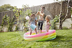 Children Having Fun In Garden Paddling Pool photo