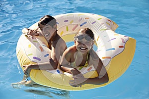 Children Having Fun With Inflatable In Outdoor Swimming Pool