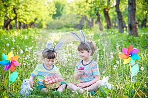 Children having fun and playing with easter eggs. two cheerful boys sit on the lawn after Easter eggs hunt