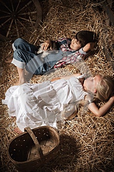 Children in the hay in the barn with a kitten