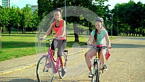 Children in helmet on bicycle by cycleway in summer park
