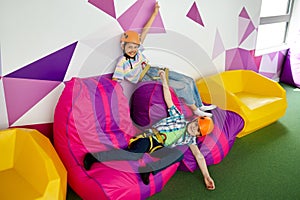 Children in helmets relaxing, young climbers