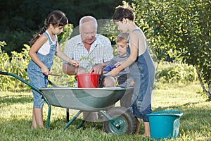 Children is helping her Grandfather in the garden