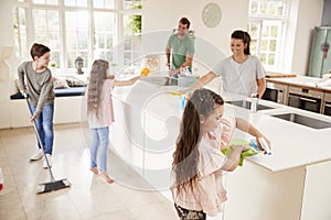 Children Helping Parents With Household Chores In Kitchen photo