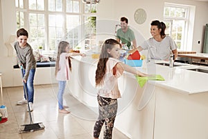Children Helping Parents With Household Chores In Kitchen photo