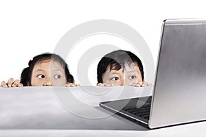 Children hiding behind white table