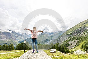 Children hiking in Alps mountains. Kids look at snow covered mountain. Spring family vacation. Little girl on hike trail