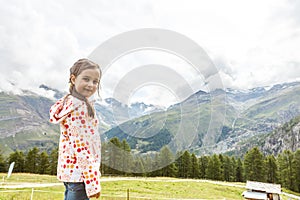 Children hiking in Alps mountains. Kids look at snow covered mountain. Spring family vacation. Little girl on hike trail