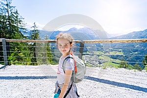 Children hiking on beautiful summer day in alps mountains Austria, resting on rock and admire amazing view to mountain