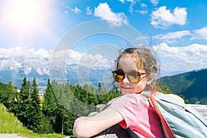 Children hiking on beautiful summer day in alps mountains Austria, resting on rock and admire amazing view to mountain