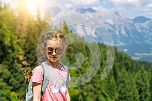 Children hiking on beautiful summer day in alps mountains Austria, resting on rock and admire amazing view to mountain