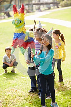 Children Hitting Pinata At Birthday Party