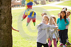 Children Hitting Pinata At Birthday Party