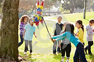 Children Hitting Pinata At Birthday Party