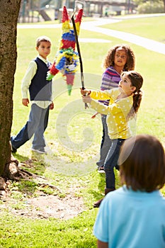 Children Hitting Pinata At Birthday Party