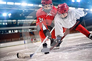 Children hockey player handling puck on ice