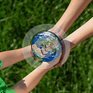 Children holding Earth planet in hands