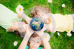 Children holding Earth planet in hands