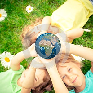 Children holding Earth planet in hands