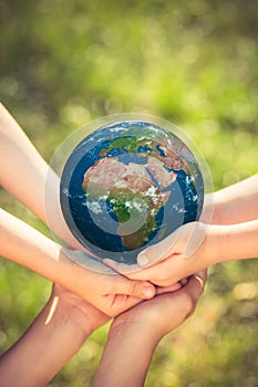 Children holding Earth planet in hands