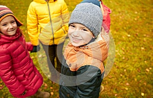 Children holding hands and playing in autumn park