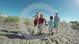 Children holding hands running on the sea beach