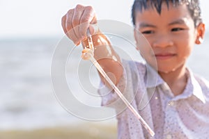 Children holding Plastic straw that he found on the beach for enviromental clean up concept