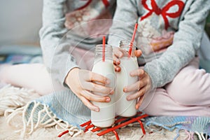 Children are holding two bottles of fresh milk