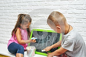 Children at home are engaged in primary education, learn to write on the blackboard .