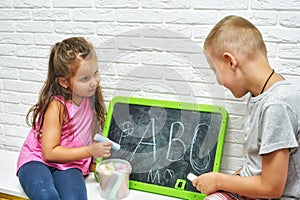 Children at home are engaged in primary education, learn to write on the blackboard .