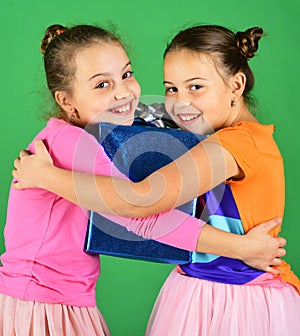 Children hug blue gift for Christmas. Sisters with gift box