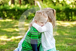 Children hug in the garden. 2-3 years. Girl and boy. The concept