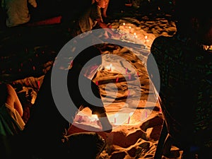 Children illuminating candles in the sand at the beach