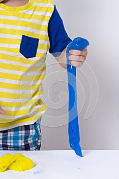 Children inflates a big bubble from a slime. Girl and boy play with slime.