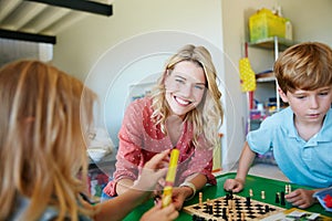 Children interact with the world around them through play. Portrait of a mother having fun with her two kids at home.