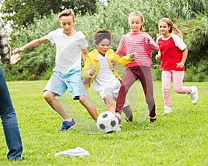 children are jogning and playing football