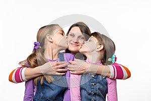 Children joyfully kiss mom, isolated on white background