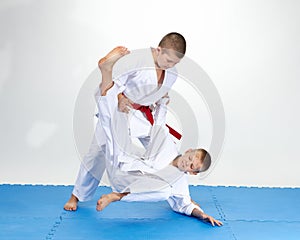 Children in judogi are training throws