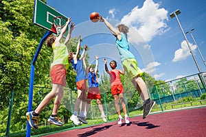 Children jump for ball during basketball game