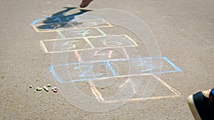 Children jump hopscotch on asphalt. Selective focus.