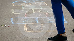 Children jump hopscotch on asphalt. Selective focus.