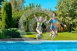 Children jump to swimming pool water and have fun, kids on family vacation